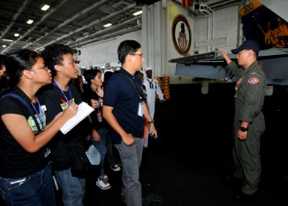 US Navy 090813-N-6233H-028 Lt. j.g. Kyler Chong, assigned to the Diamondbacks of Strike Fighter Squadron (VFA) 102, explains how an F-A 18C Hornet operates to students from Manila high schools