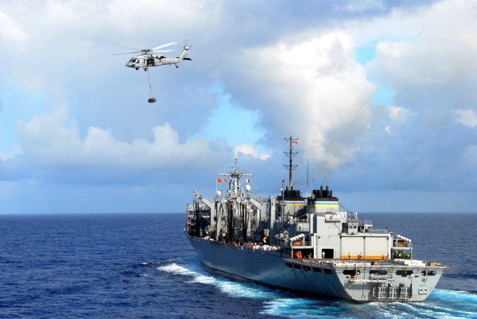 US Navy 090815-N-2918M-117 An MH-60S Sea Hawk helicopter assigned to the Wildcards of (HSC) 23 delivers supplies from the Military Sealift Command fast combat support ship USNS Bridge (T-AOE 10) to the aircraft carrier USS Nimi