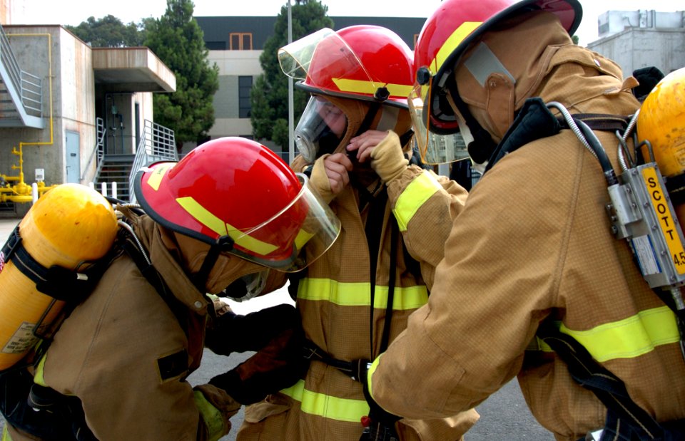 US Navy 090818-N-4047W-060 Members of the Damage Control Olympics team from the Ticonderoga-class guided-missile cruiser USS Mobile Bay (CG 53) help each other properly don firefighting ensembles