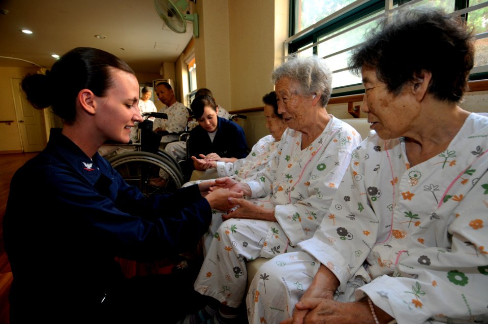 US Navy 090819-N-4399G-048 Ship's Serviceman 3rd Class Michelle Worthing, left, and Ship's Serviceman Seaman Breanne Markey message the hands of residents of the Blue Bird Senior Citizens Center