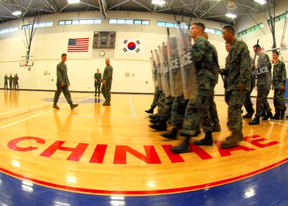 US Navy 090817-N-9573A-018 Marines assigned to Fleet Anti-terrorism Security Team, Company Pacific (FASTPAC), instruct Sailors as they march in formation with shields and batons during riot training