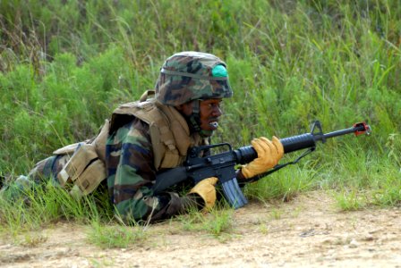 US Navy 090819-N-1580K-133 Construction Electrician Constructionman Apprentice Brandon Bates, assigned to Naval Mobile Construction Battalion (NMCB) 22, takes a fighting position during quick reaction force training at Camp She