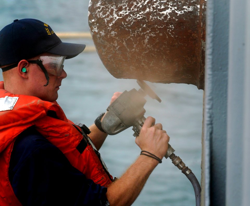 US Navy 090817-N-7280V-455 Culinary Specialist Seaman James Brown, assigned to the amphibious command ship USS Blue Ridge (LCC 19), preserves an exhaust pipe on the side of the ship while in Korea