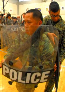 US Navy 090817-N-9573A-024 Builder 1st Class Crisostoma Alba, from Virginia Beach, Va., stands ready with a shield and baton during riot training