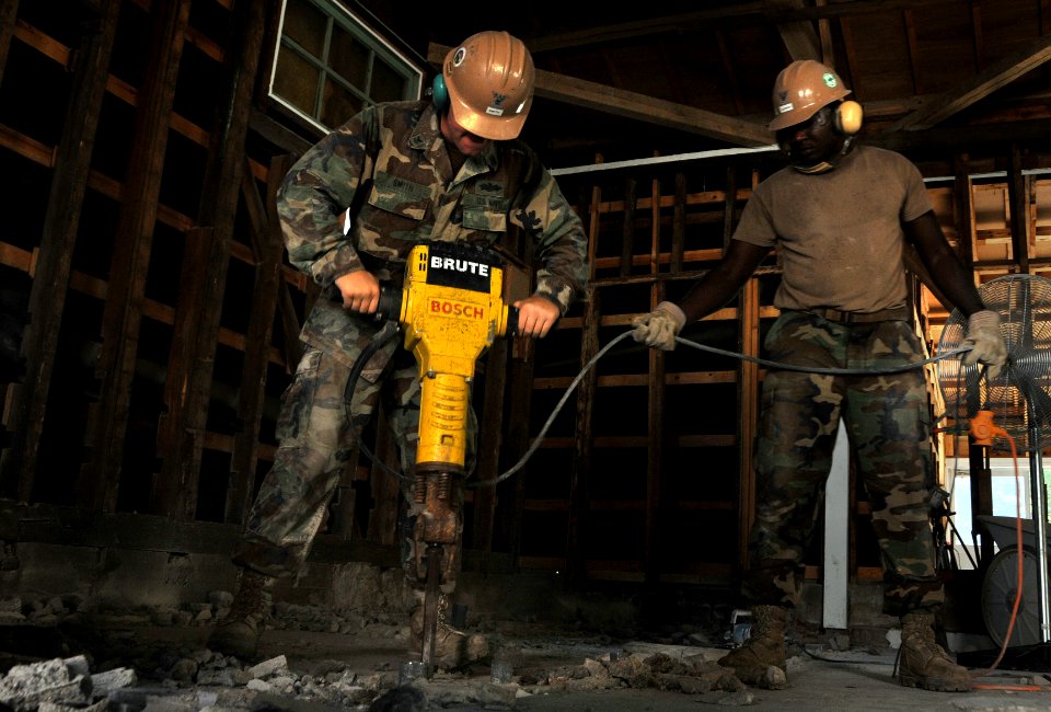 US Navy 090818-N-0807W-092 Construction Electrician 2nd Class Eric Smith and Utilitiesman 2nd Class Kareen Vilbrun break down rocks with a jackhammer during a building renovation