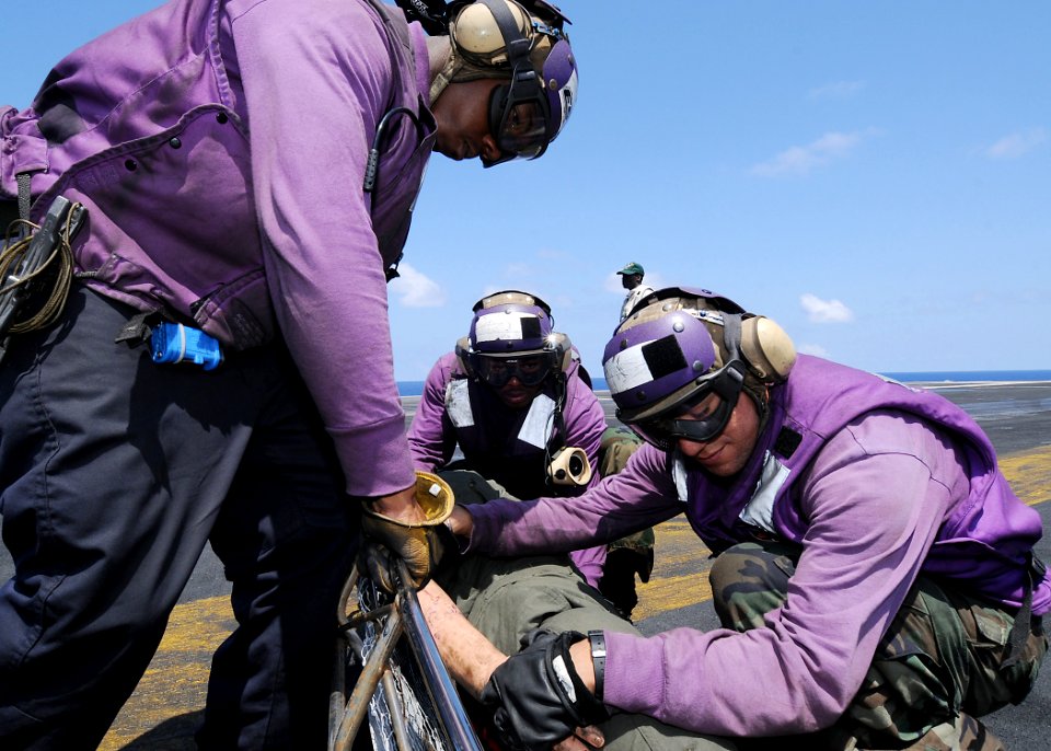 US Navy 090821-N-1062H-056 Sailors assigned to the Air department of the aircraft carrier USS George Washington (CVN 73) move a simulated casualty during a flight deck drill