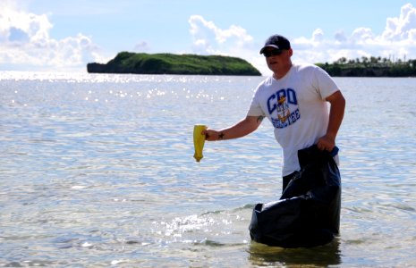 US Navy 090819-N-1906L-002 Sonar Technician (Submarine) 1st Class (Chief Select) Micah Hardin, assigned to Commander, Submarine Squadron 15, trash from Dadi Beach