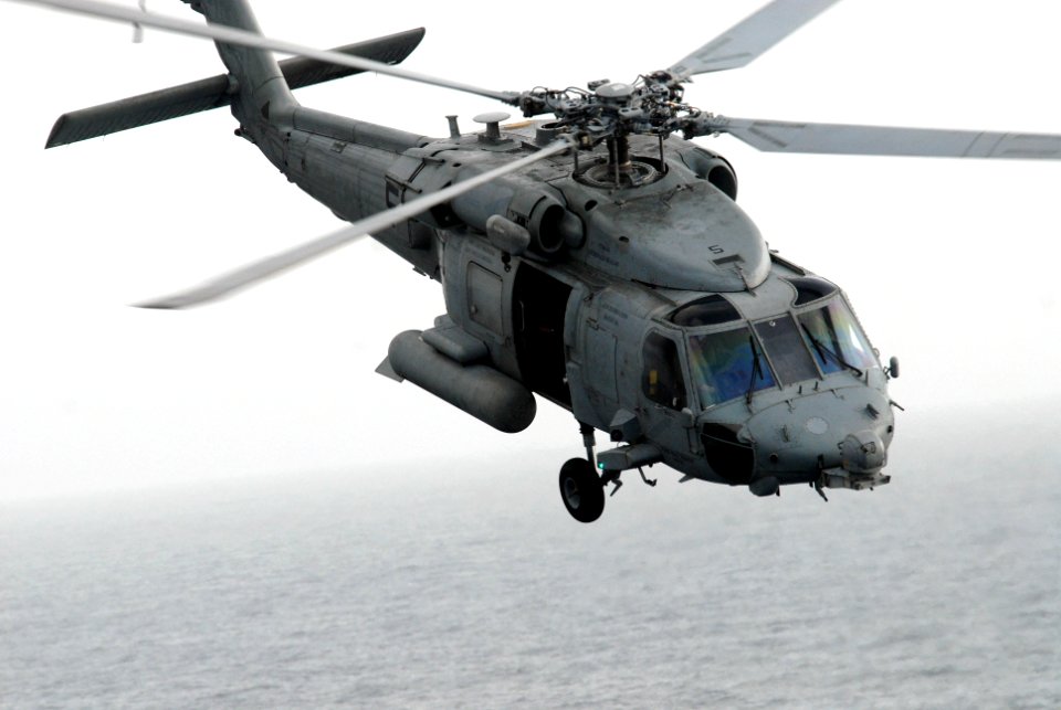 US Navy 090820-N-5586R-024 An MH-60S Sea Hawk helicopter assigned to the Blackjacks of Helicopter Sea Combat Squadron (HSC) 21 maneuvers between the Military Sealift Command fast-combat support ship USNS Rainier (T-AOE 7) and t