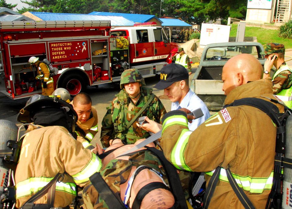 US Navy 090819-N-9573A-018 Firefighters and medical personnel prepare a training dummy for transport to a medical facility during a fire saboteur drill