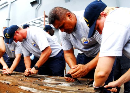 US Navy 090820-N-0995C-055 Chief petty officer selects scrape paint from the teak deck of the USS Missouri Memorial (BB 63) during a project to refurbish the ship