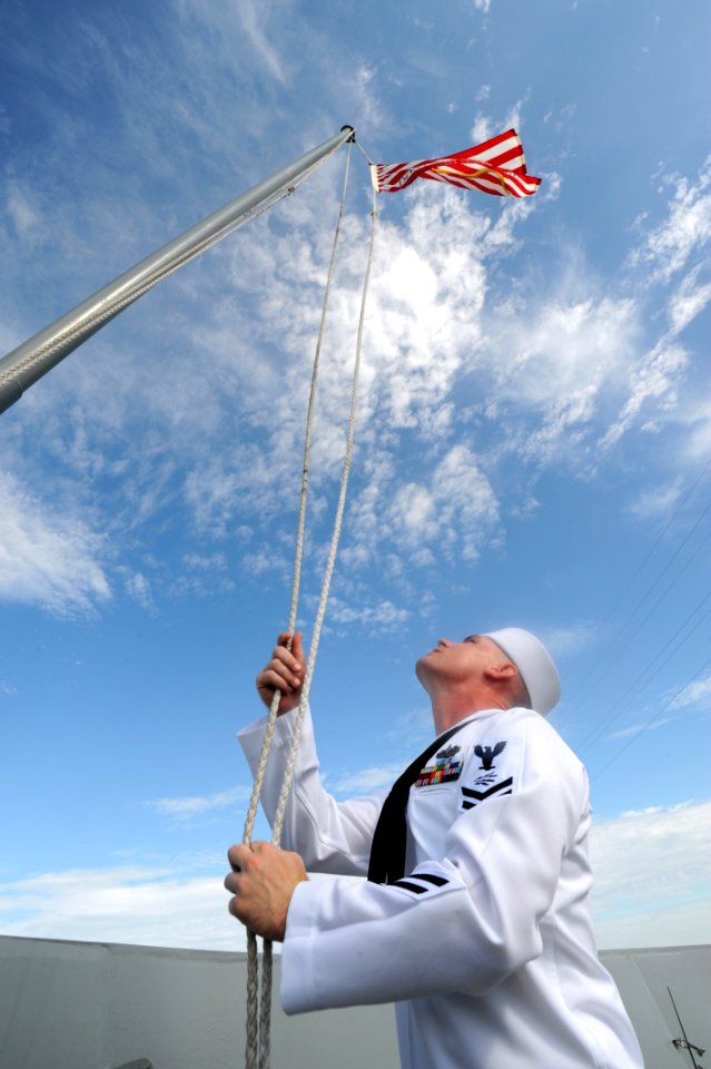 US Navy 090821-N-2147L-001 Information Systems Technician 2nd Class James Alcorn raises the Navy Jack for the first time aboard the amphibious transport dock ship Pre-Commisioning Unit (PCU) New York (LPD 21) photo