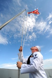 US Navy 090821-N-2147L-001 Information Systems Technician 2nd Class James Alcorn raises the Navy Jack for the first time aboard the amphibious transport dock ship Pre-Commisioning Unit (PCU) New York (LPD 21) photo