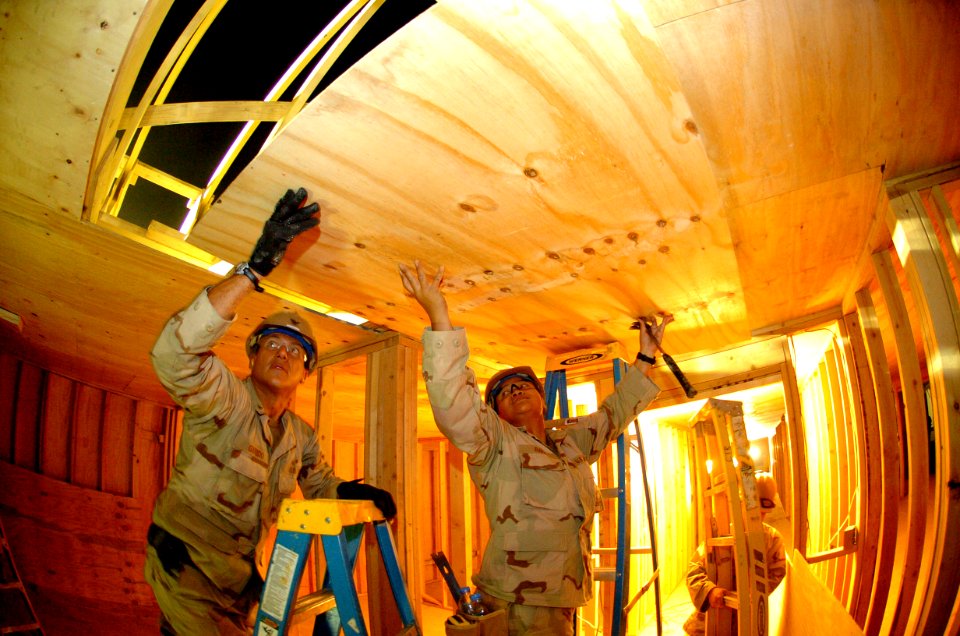 US Navy 090821-N-4440L-054 Naval Mobile Construction Battalion (NMCB) 74 Builder 3rd Class Daniel Garrido, left, Builder 3rd Class Joanna Ra Ra, and Builder Constructionman Christopher Mercure put up a plywood ceiling in a Sout