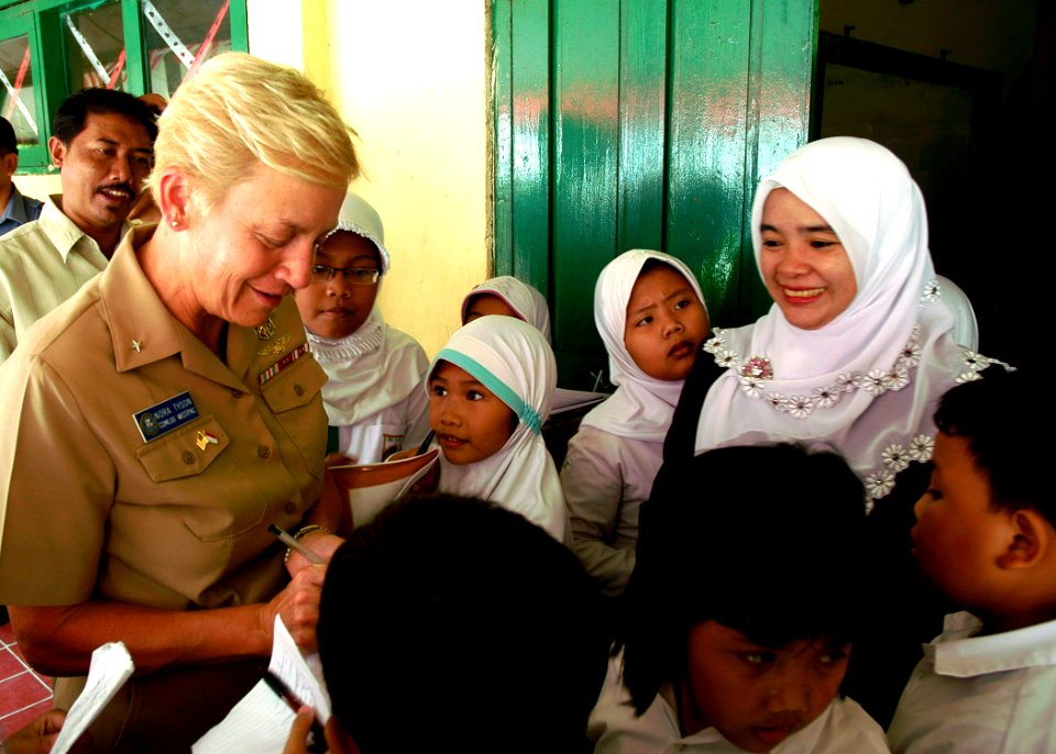 US Navy 090825-N-8539M-134 Rear Adm. Nora Tyson, commander, Logistics Group Western Pacific, signs autographs for students at Nural Falah Elemetary School