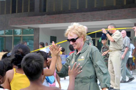 US Navy 090826-N-9689V-013 Donna Willard, wife of U.S. Pacific Fleet commander Adm. Robert F. Willard, high-fives children at Betio Sports Complex during a Pacific Partnership 2009 medical civic action project