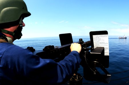 US Navy 090824-N-1522S-010 Gunner's Mate 2nd Class Jeffrey Drake watches the Navy training boat USNS Hunter (8202) for signs of threats while manning a .50-caliber machine gun during a visit, board, search, and seizure training