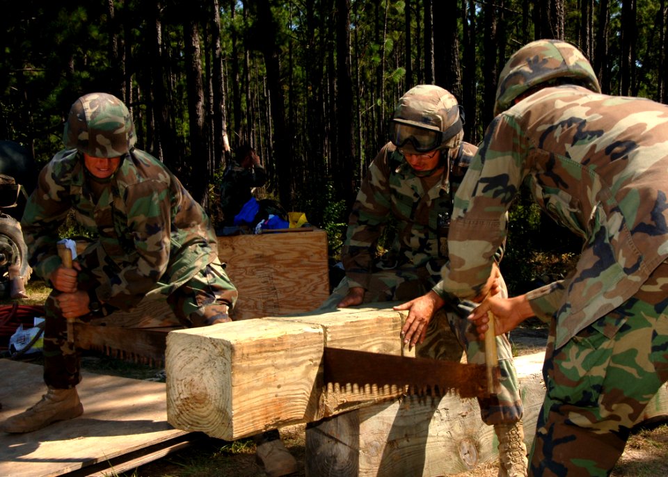 US Navy 090824-N-8816D-118 Seabees assigned to Naval Mobile Construction Battalion (NMCB) 133 saw timber for a tower during a field training exercise at Camp Shelby, Miss