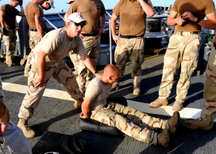 US Navy 090827-N-6814F-054 U.S. Coast Guard Machinery Technician 1st Class Dan Morales, assigned to maritime safety and security team 91104, instructs visit, board, search, and seizure team members