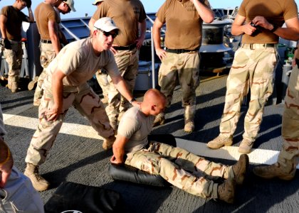 US Navy 090827-N-6814F-054 U.S. Coast Guard Machinery Technician 1st Class Dan Morales, assigned to maritime safety and security team 91104, instructs visit, board, search, and seizure team members photo