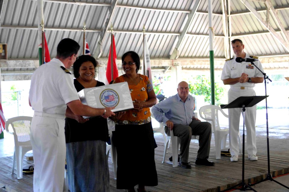 US Navy 090824-N-9689V-005 Mission chaplain Lt. Todd Delaney, presents representatives from the Red Cross and the Kiribati Association of Non-Governmental Organizations, with donations on behalf of Project Handclasp