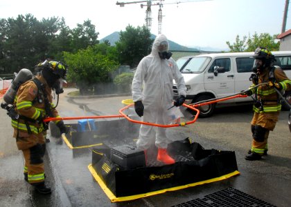 US Navy 090825-N-9573A-007 Firefighters wash down John Reece, from Harwich, Mass., in a decontamination station after using the Portal Shield Advanced Concept Technology (ACTD)