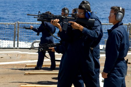 US Navy 090825-N-9123L-122 Seaman Michael Dokter fires an M-16 rifle as Fire Controlman 2nd Class Chaung Pha acts as his spotter during small arms qualifications aboard the guided-missile destroyer USS McCampbell (DDG 85)