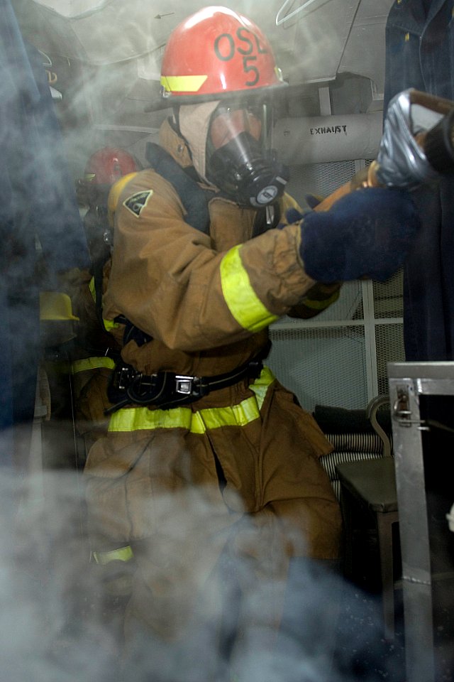 US Navy 090828-N-9123L-061 Ship's Serviceman 1st Class Leo Malana, from Vallejo, Calif., enters a smoke-filled space during a damage control training exercise aboard the guided-missile destroyer USS McCampbell (DDG 85)