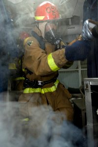 US Navy 090828-N-9123L-061 Ship's Serviceman 1st Class Leo Malana, from Vallejo, Calif., enters a smoke-filled space during a damage control training exercise aboard the guided-missile destroyer USS McCampbell (DDG 85)