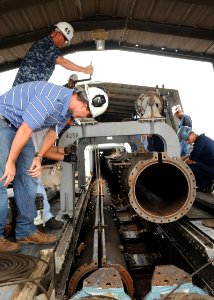 US Navy 090901-N-5082P-006 ailors assigned to the aircraft carrier USS Enterprise (CVN 65) and Northrop Grumman, Newport News shipyard workers lower the power cylinder of catapult four in place on the ship's flight deck