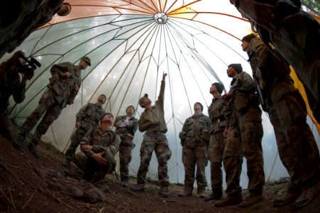 US Navy 090826-O-1234S-035 Center for Security Forces instructor Gerald Fine, center, instructs members from the 2009 class of NASA astronaut candidates on the uses of a parachute canopy for shelter during a week of survival tr photo