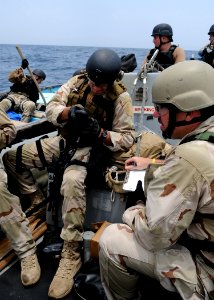 US Navy 090901-N-6814F-148 U.S. Coast Guard Lt j.g. Jared Hitzel, maritime safety and security team 91104 officer in charge, examines a global positioning satellite handheld device during a boarding operation photo
