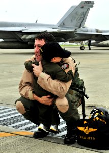 US Navy 090902-N-4031K-001 Lt. Cmdr. Mike Kinter, assigned to the Royal Maces of Strike Fighter Squadron (VFA) 27, hugs his son during a homecoming celebration for Carrier Air Wing 5