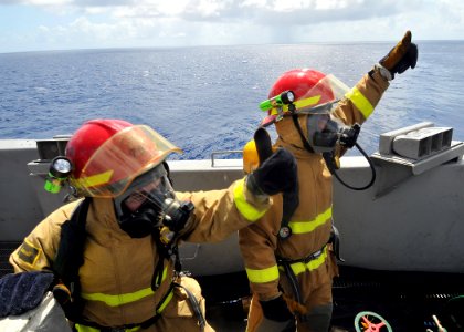 US Navy 090902-N-6233H-014 Aviation Electrician's Mate Airman Brendon Phillips and Yeoman 3rd Class Fernando Ramirez signal they are ready to charge a fire hose during the damage control Olympics aboard the aircraft carrier USS