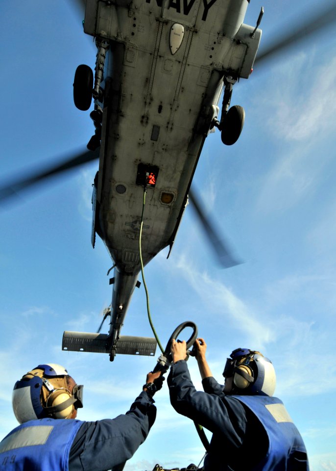 US Navy 090829-N-2638R-005 oatswain's Mate Seaman Tiffany Walker and Seaman Adam Komperda attach a load to an MH-60S Sea Hawk helicopter