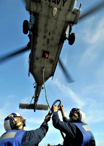 US Navy 090829-N-2638R-005 oatswain's Mate Seaman Tiffany Walker and Seaman Adam Komperda attach a load to an MH-60S Sea Hawk helicopter