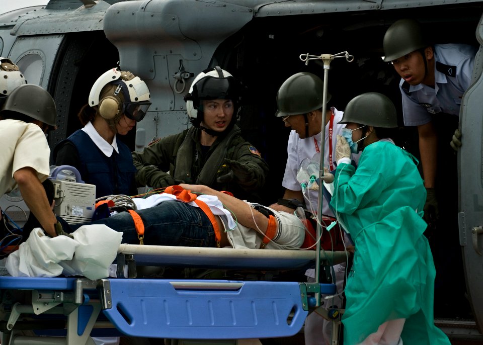 US Navy 090830-N-5253W-099 A naval air crewman assigned to Sea Combat Helicopter Squadron (HSC) 25 assists Japanese service members and nurses from the Japan Self-Defense Force Central Hospital