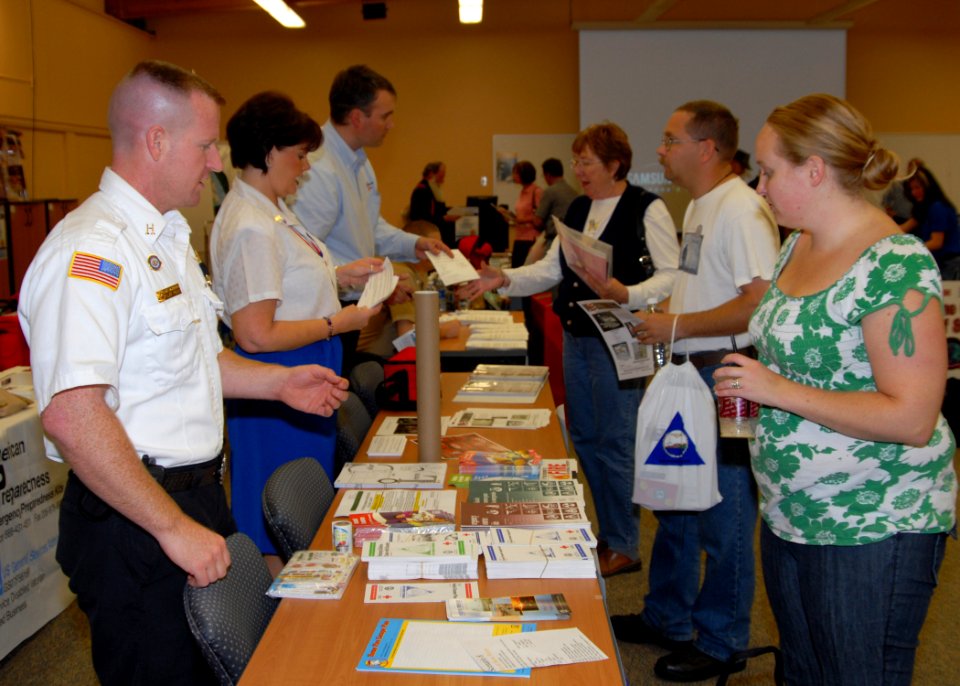 US Navy 090902-N-9860Y-001 Cliff Foley, a Navy Region Northwest Fire and Emergency Services fire inspector, discusses fire safety with an attendee to the Operation Prepare information fair