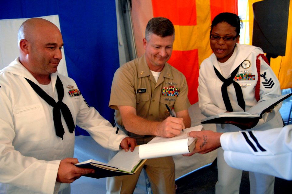 US Navy 090827-N-9818V-646 Master Chief Petty Officer of the Navy (MCPON) Rick West signs charge books of chief petty officer selects during a heritage training formal dinner aboard the USS Constitution