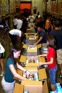 US Navy 090903-N-5366K-100 Recruiters assigned to the Ohio Navy Recruiting District and members of the Navy parachute team work a production line with civilians to box food at the Mid-Ohio food bank during the Central Ohio Navy photo