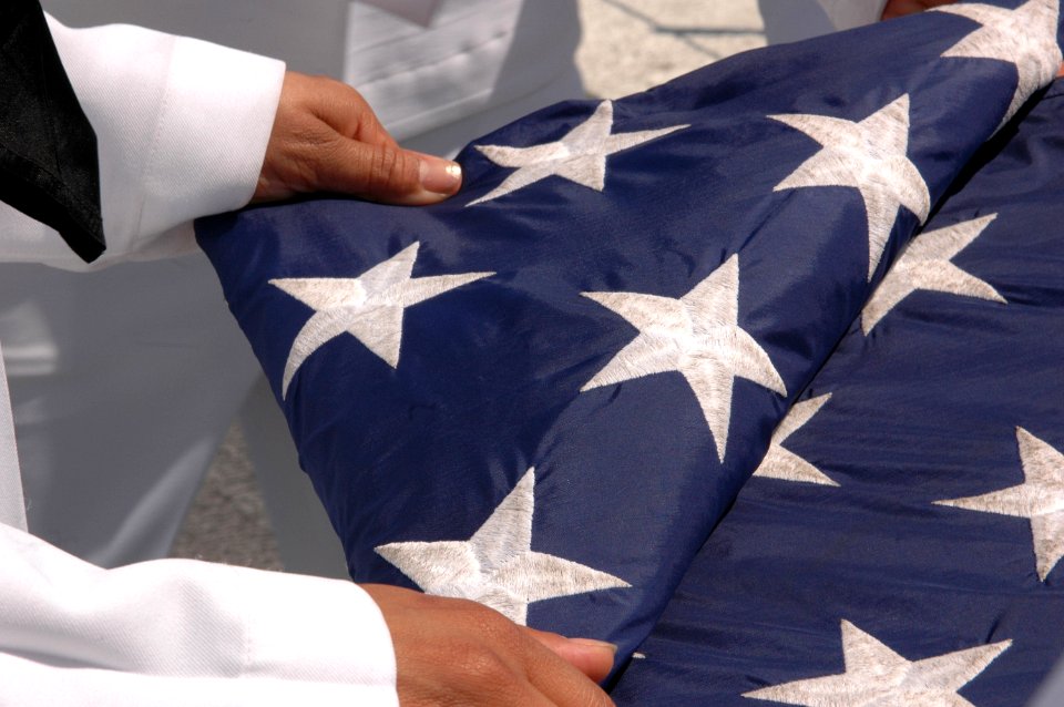 US Navy 090828-N-8960W-028 ailors assigned to the colors detail fold the national ensign on the flight deck of the aircraft carrier USS Nimitz (CVN 68)