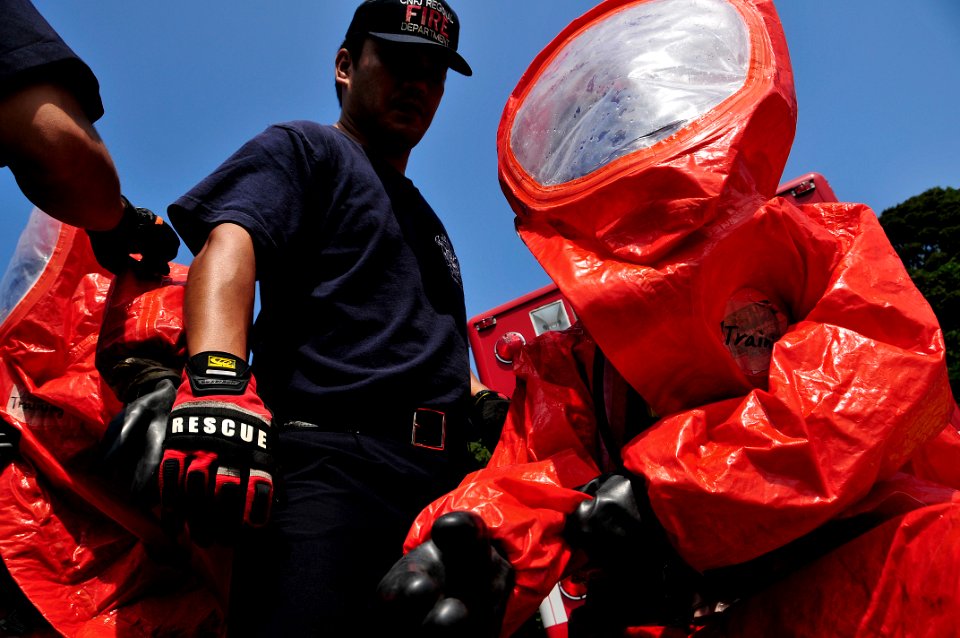 US Navy 090901-N-0807W-265 Firefighters from Commander, U.S. Naval Forces Japan (CNFJ) Regional fire department don protective suits before responding to a simulated chemical spill