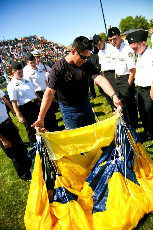 US Navy 090902-N-3271W-118 Aircrew Survival Equipmentman 1st Class Victor Maldonado, assigned to the U.S. Navy parachute team, the Leap Frogs, shows Navy Junior ROTC students how to pack his parachute after jumping into Frankli