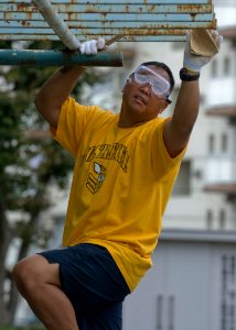 US Navy 090902-N-5253W-041 Boatswain's Mate 1st Class Rhoniel Suarez, a chief petty officer (CPO) select from Pasadena, Calif., sands playground equipment for painting during a community service project at the Morisaki Playgro