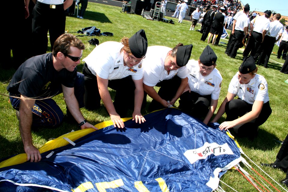 US Navy 090902-N-5366K-037 hief Special Warfare Operator (SEAL) Justin Gauny shows Navy Junior ROTC members how to pack his parachute