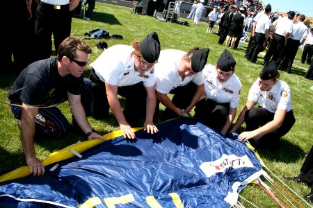 US Navy 090902-N-5366K-037 hief Special Warfare Operator (SEAL) Justin Gauny shows Navy Junior ROTC members how to pack his parachute photo