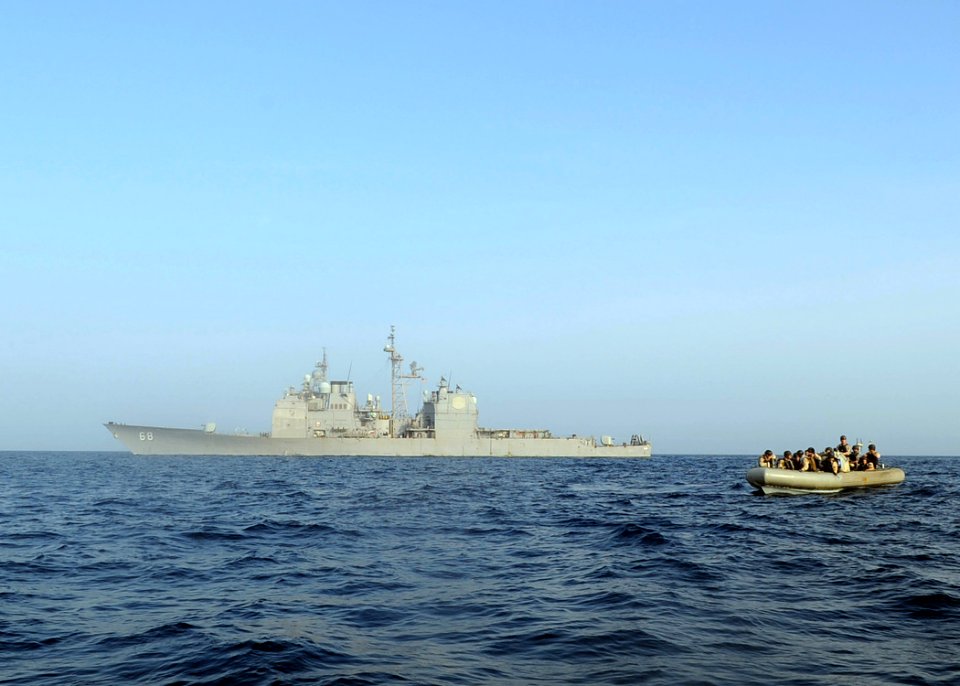 US Navy 090910-N-6814F-138 A Navy and U.S. Coast Guard visit, board, search, and seizure team provides cover during a right-of-visit boarding near the guided-missile cruiser USS Anzio (CG 68)
