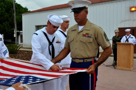 US Navy 090911-N-1825E-082 Chief Information Systems Technician (Sel.) John Ceasar cuts the national ensign during a flag retirement ceremony photo