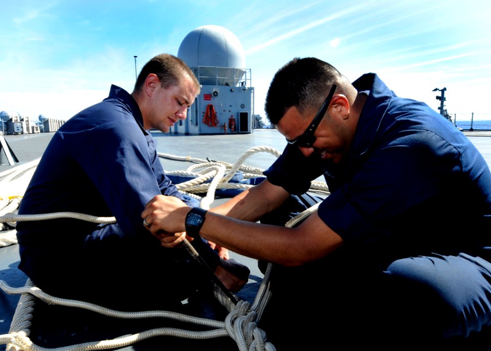 US Navy 090910-N-7280V-187 Boatswain's Mate Seaman Robert Daub and Gunner's Mate Seaman Don Flores splice Kevlar mooring lines