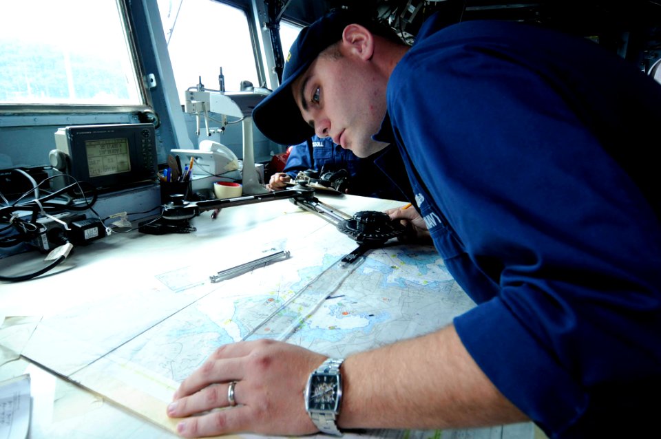 US Navy 090908-N-7478G-005 Quartermaster 1st Class Daniel McElvaney uses a parallel motion protractor to plot coordinates aboard the amphibious command ship USS Blue Ridge (LCC 19)