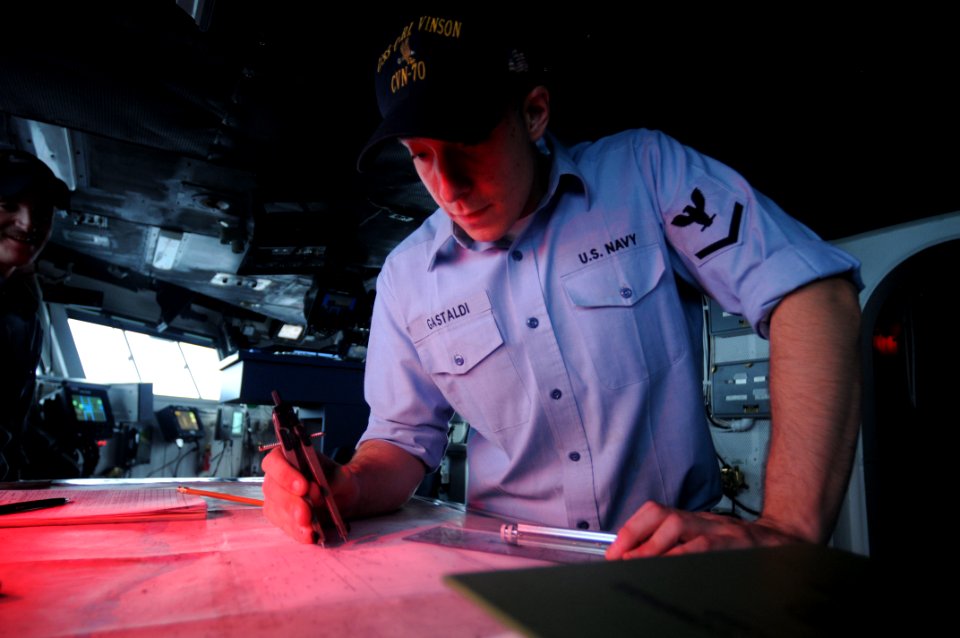 US Navy 090911-N-9132C-017 Quartermaster 3rd Class Daniel Gastaldi, assigned to the Nimitz class aircraft carrier USS Carl Vinson (CVN 70), plots a chart at the navigation table on the bridge of the aircraft carrier USS Ronald
